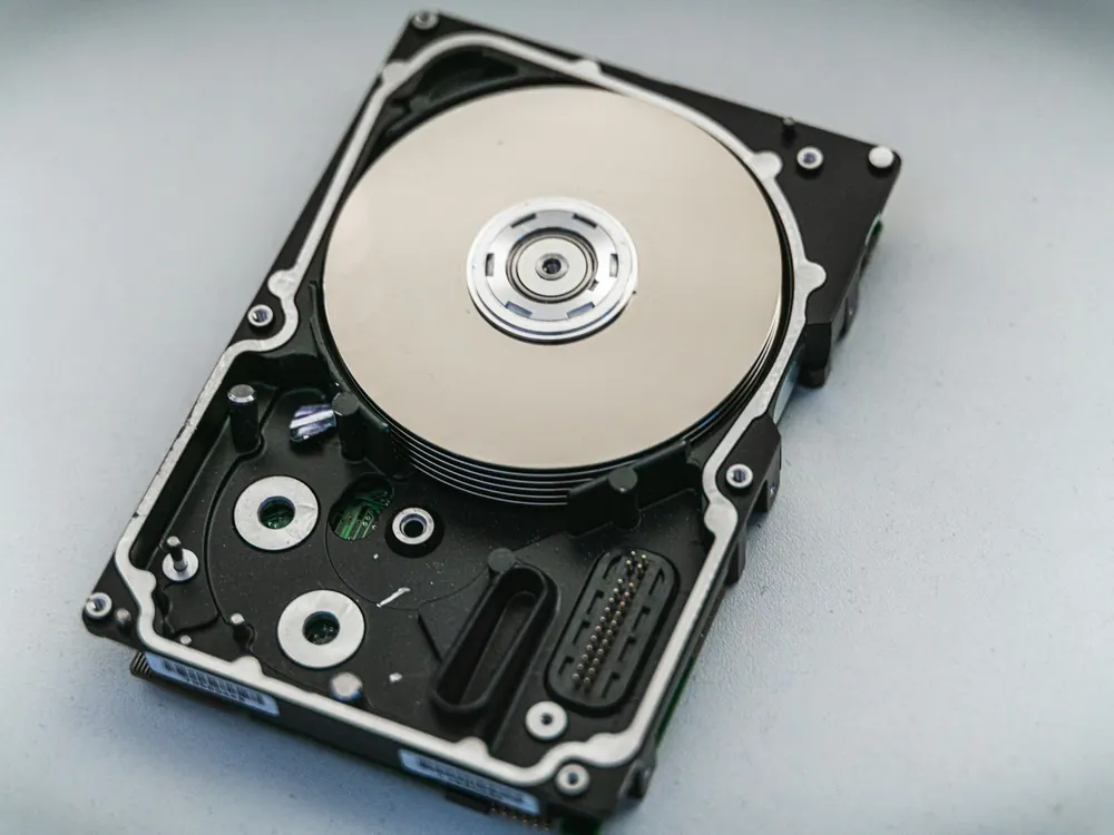 Açık zemin üzerinde kapağı açılmış bir sabit disk